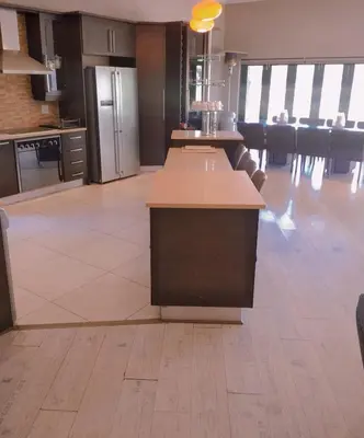 a kitchen with a island in the middle of a room at Pecanwood Relaxing Villa - Golf, Pool, Braai & Dam Views in Hartbeespoort