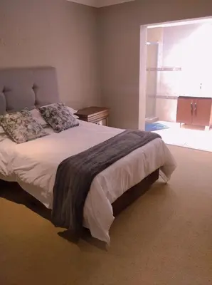 a bedroom with a large bed with a large window at Pecanwood Relaxing Villa - Golf, Pool, Braai & Dam Views in Hartbeespoort