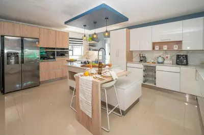a kitchen with white cabinets and a blue ceiling at Grace House, Mkhuhlu, spacious 4-bedroom house in Belfast