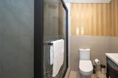a bathroom with a shower with a toilet and a sink at Grace House, Mkhuhlu, spacious 4-bedroom house in Belfast