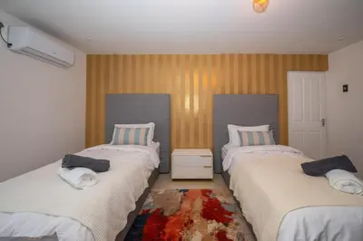 a bedroom with two beds with towels on them at Grace House, Mkhuhlu, spacious 4-bedroom house in Belfast