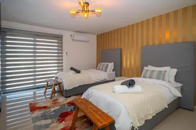 a bedroom with two beds and a table at Grace House, Mkhuhlu, spacious 4-bedroom house in Belfast