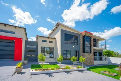 a contemporary house with a red door at Grace House, Mkhuhlu, spacious 4-bedroom house in Belfast