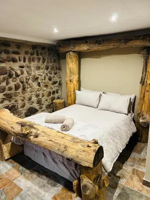 a bedroom with a wooden bed in a stone wall at Stonehouse in Carolina