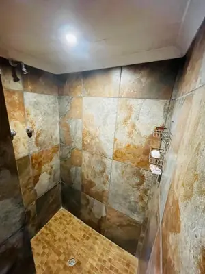 a bathroom with a shower with a tiled wall at Stonehouse in Carolina