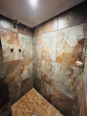 a bathroom with a tiled wall and a shower at Stonehouse in Carolina
