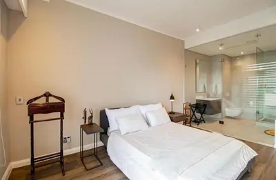 a bedroom with a large white bed and a bathroom at Luxury AT Maine in Pretoria