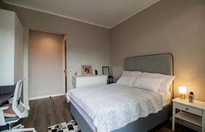 a bedroom with a bed and two night stands and a desk at Luxury AT Maine in Pretoria