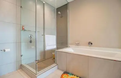 a bathroom with a shower and a bath tub at Luxury AT Maine in Pretoria