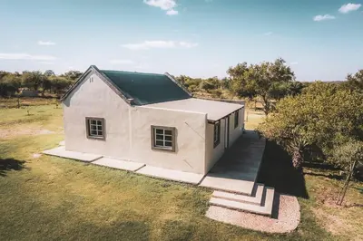 a small white house with a green roof at Die Skoen in Dinokeng Game Reserve