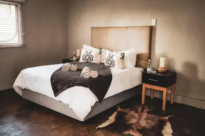 a bedroom with a large bed with two candles on it at Die Skoen in Dinokeng Game Reserve