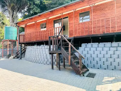 a building with a wooden staircase in front of it at The Man Cave in Sabie