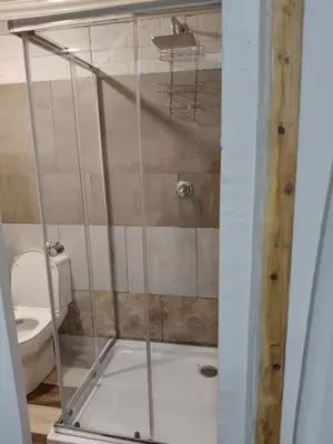 a shower stall in a bathroom with a toilet at The Man Cave in Sabie