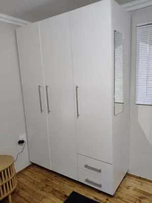 a large white cabinet in a room with a table at The Man Cave in Sabie