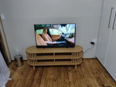 a tv sitting on top of a wooden entertainment center at The Man Cave in Sabie