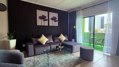a living room with a couch and a table at Forest Haven in Midrand
