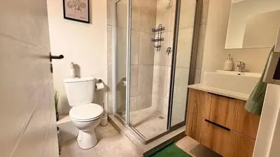 a bathroom with a shower and a toilet and a sink at Forest Haven in Midrand