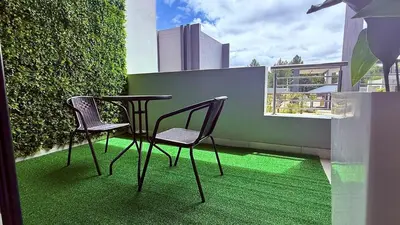 two chairs and a table on a balcony with green grass at Forest Haven in Midrand