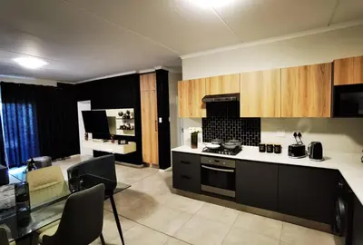 a kitchen with a table and a stove top oven at Forest Haven in Midrand