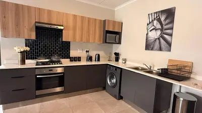 a kitchen with a sink and a stove top oven at Forest Haven in Midrand