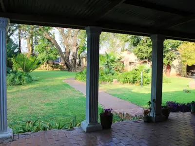 a view of a garden from a porch at Phomola Guesthouse in Brits