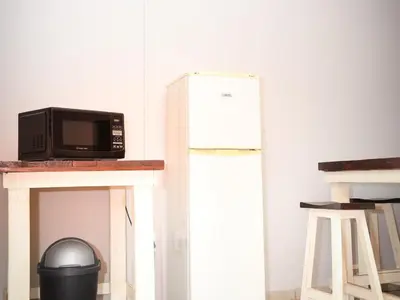 a microwave sitting on a counter next to a refrigerator at Phomola Guesthouse in Brits