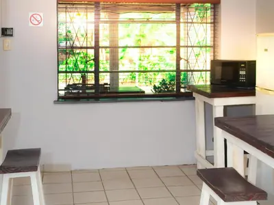 a kitchen with a window and a table and chairs at Phomola Guesthouse in Brits