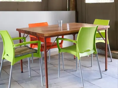 a wooden table with green chairs around it at Phomola Guesthouse in Brits