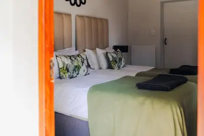 a bedroom with two beds and a mirror at Ingaadi in Pretoria