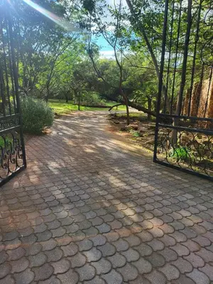a stone path with two gates and trees at Irene Villa in Irene