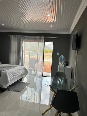 a bedroom with a bed and a glass table at Okuhle guesthouse in Mahlakwena