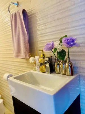 a bathroom sink with flowers on top of it at The Ridge At Mountain View Vacation Home in Boschrand