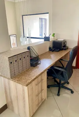 an office with a desk with a printer and a chair at The Ridge At Mountain View Vacation Home in Boschrand