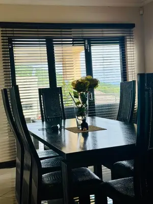 a dining room table with a vase of flowers on it at The Ridge At Mountain View Vacation Home in Boschrand
