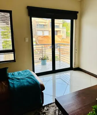 a bedroom with a large glass door to a balcony at The Ridge At Mountain View Vacation Home in Boschrand