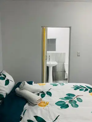 a bedroom with a bed with a floral bedspread at Linies guest house in Benoni
