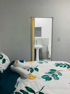 a bedroom with a bed with a floral bedspread at Linies guest house in Benoni