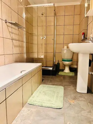 a bathroom with a sink and a tub and a toilet at Linies guest house in Benoni