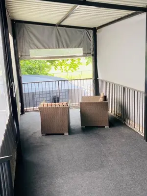 a screened porch with two wicker chairs on a balcony at Linies guest house in Benoni