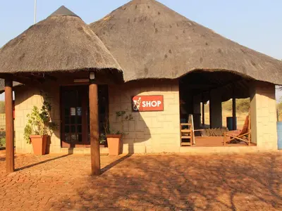 a small building with a thatched roof at My Bush Camp in Settlers