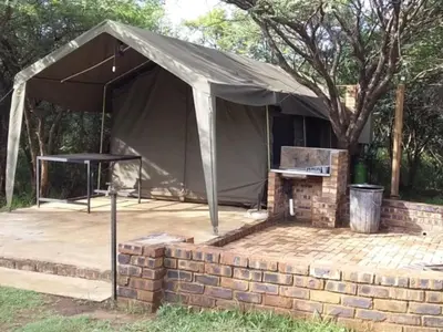 a tent with a table and a grill at My Bush Camp in Settlers