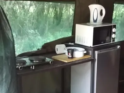 a microwave on top of a table in a trailer at My Bush Camp in Settlers