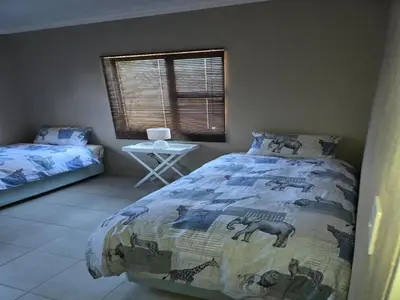 a bedroom with a bed with a comforter with animals on it at My Bush Camp in Settlers
