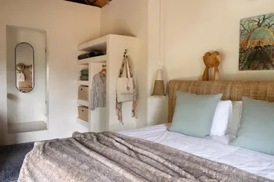 a bedroom with a bed with a blanket on it at Sashwa River of Stars Plant-Based Wellness Safari Lodge in Hoedspruit