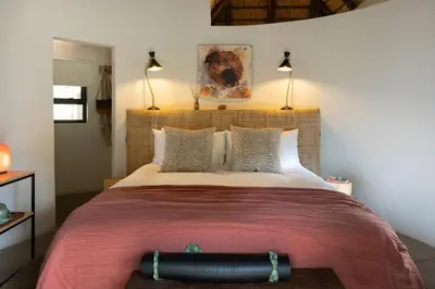 a bedroom with a large bed with a large headboard at Sashwa River of Stars Plant-Based Wellness Safari Lodge in Hoedspruit