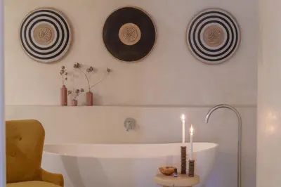 a bathroom with two plates and a sink with candles at Sashwa River of Stars Plant-Based Wellness Safari Lodge in Hoedspruit