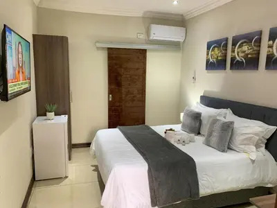a bedroom with a bed with a dog laying on it at The Pillows Suites Villa in Pretoria