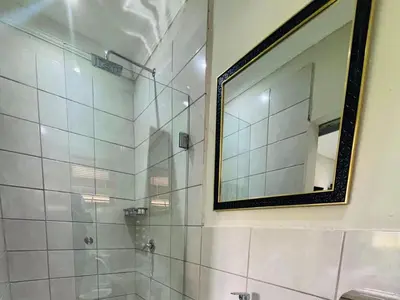 a bathroom with a mirror and a shower at The Pillows Suites Villa in Pretoria