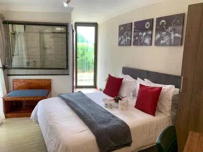 a bedroom with a large white bed with red pillows at The Pillows Suites Villa in Pretoria