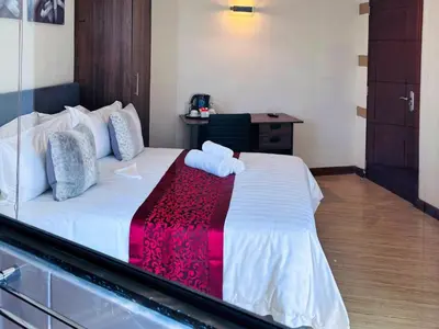 a bedroom with a white bed with a red blanket at The Pillows Suites Villa in Pretoria